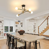 Modern dining room with a chandelier, table, and chairs.